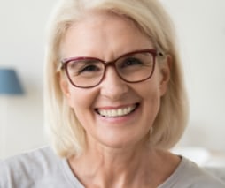 middle aged woman wearing glasses smiling